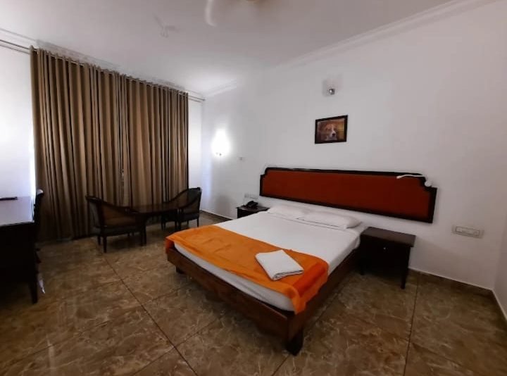 Double bedroom with wooden headboard at ATS Willingdon Hotel